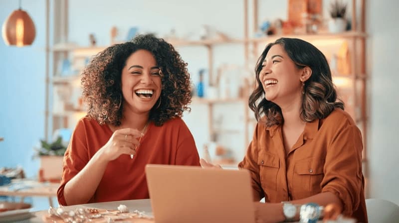 Imagem de duas mulheres rindo durante uma reunião